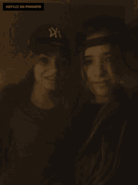two girls are standing next to each other and one has a ny hat