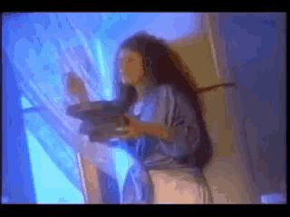a woman with long hair stands in front of a mirror