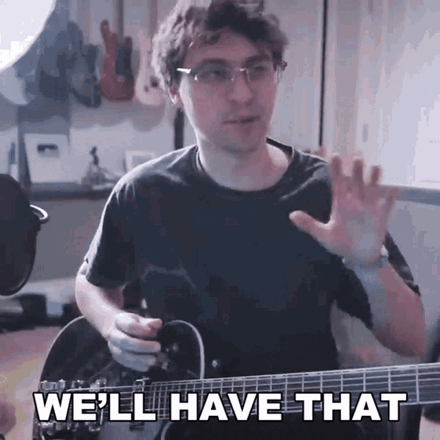 a man playing a guitar with the words we 'll have that behind him