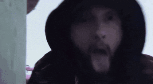 a man with a beard is wearing a black hood