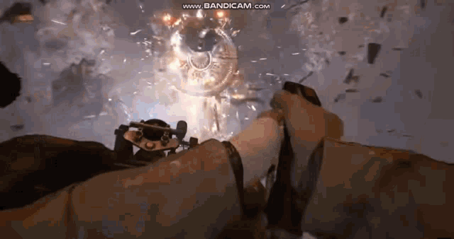a person is holding a gun in a video game and there is a explosion behind them .