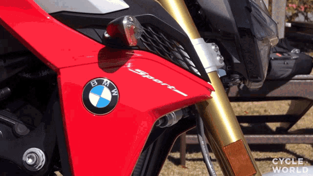 a red bmw sport motorcycle is parked in front of a picnic table