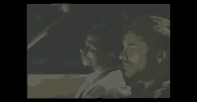 two men sitting in a car looking out the window