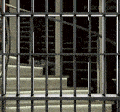 a jail cell with stairs in the background and a sign that says police