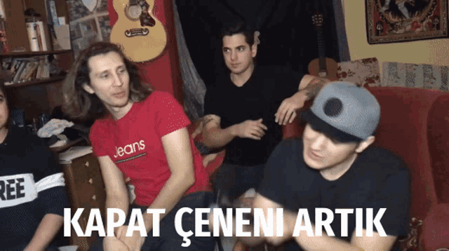 a man wearing a red jeans shirt sits next to a man wearing a black shirt