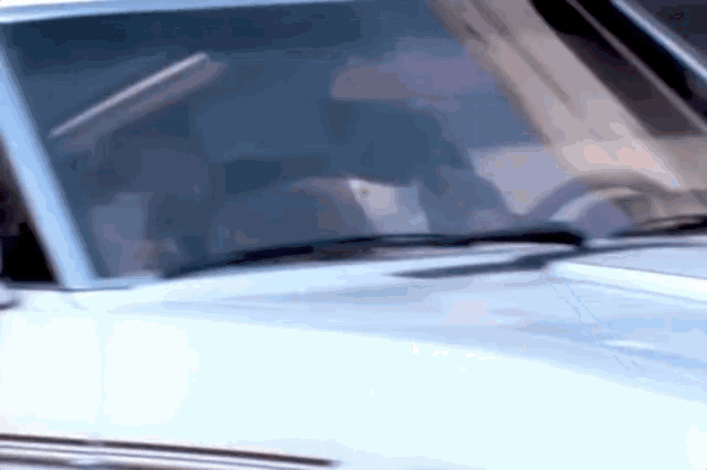 a close up of a car windshield with a person driving it