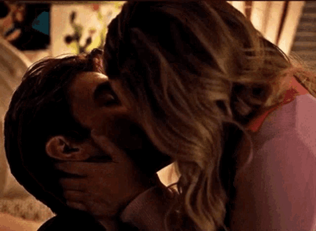 a man and a woman are kissing each other in a dark room .