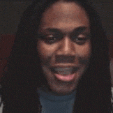 a close up of a woman making a funny face while sitting at a table .