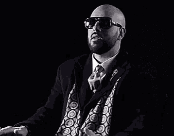 a man in a suit and tie is wearing sunglasses and says chasse dans la gargante
