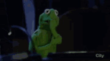 kermit the frog from the muppet show is holding his hand to his chin and thinking .
