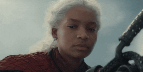 a woman with white hair is holding a sword in her hand