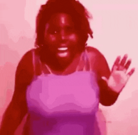 a woman in a pink tank top is waving her hand in a red background .
