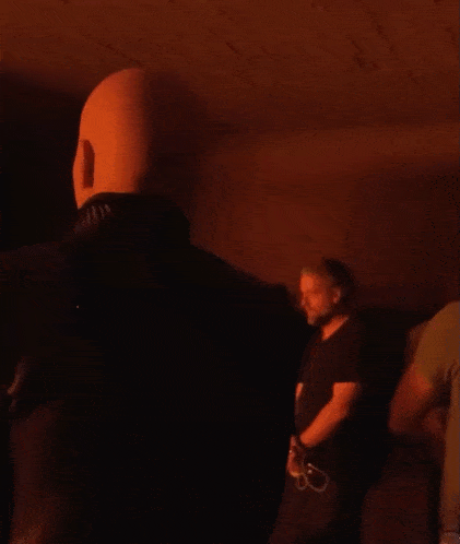 a man in a black shirt is standing in the dark
