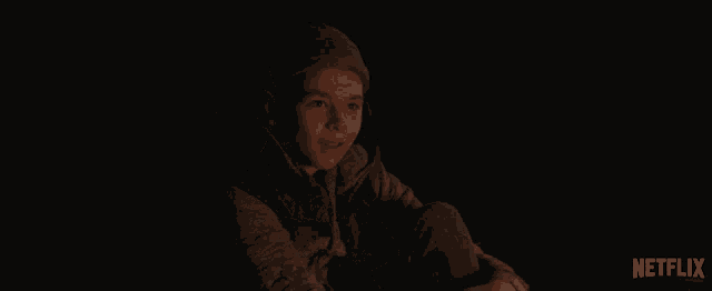 a person in a dark room with a netflix logo behind them