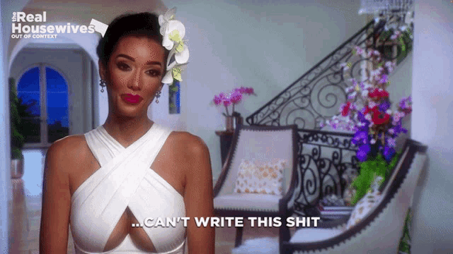 a woman in a white dress says " can 't write this shit " in front of a chair