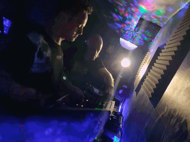 a man in a black shirt with a skull on it is playing a dj set