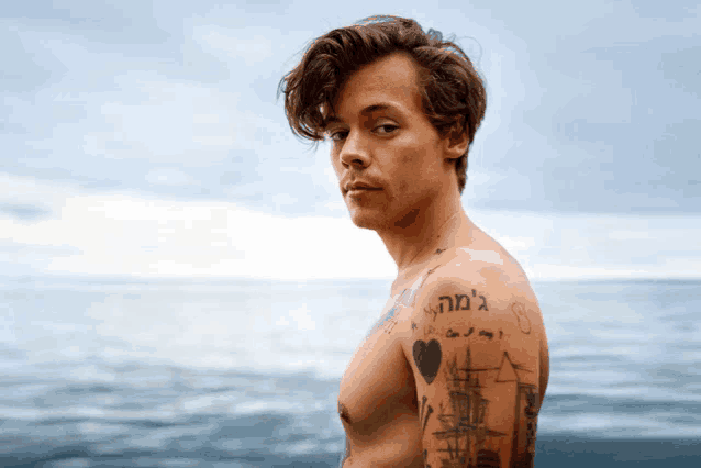 a shirtless man with a tattoo on his arm that says " can i say "