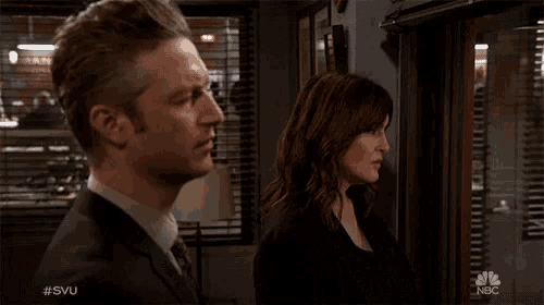 a man and a woman are looking at each other in a room with a nbc logo in the corner