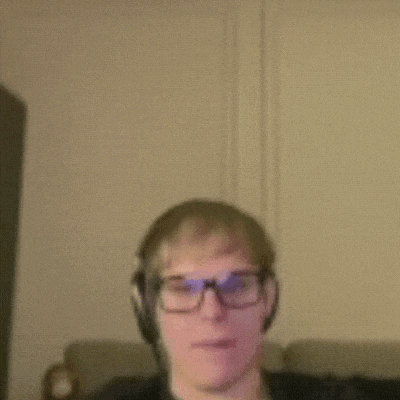 a man wearing glasses and headphones is sitting on a couch .