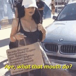 a woman holding a bag with the words aye what that mouth do on it
