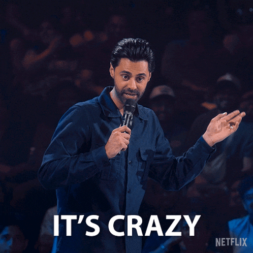 a man holding a microphone with the words it 's crazy on the bottom