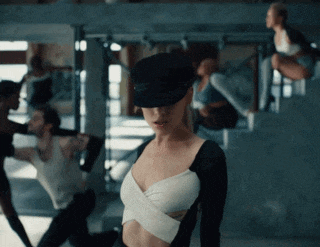a woman wearing a black hat stands in front of a group of people