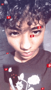 a young boy with curly hair is wearing a black shirt with a picture of mickey mouse on it
