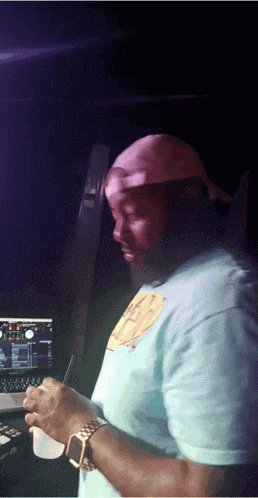 a man wearing a t-shirt that says ' a ' on it stands in front of a laptop