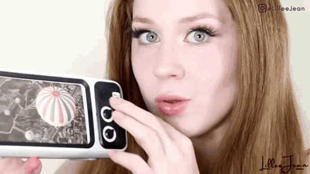 a woman is taking a picture of herself with a cell phone and the name lillie jean is on the bottom
