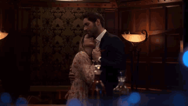 a man and a woman are hugging in a dark room .