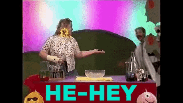 a woman stands in front of a table that says he-hey