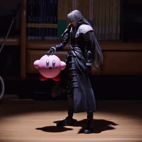 a man in a black coat is holding a pink kirby doll