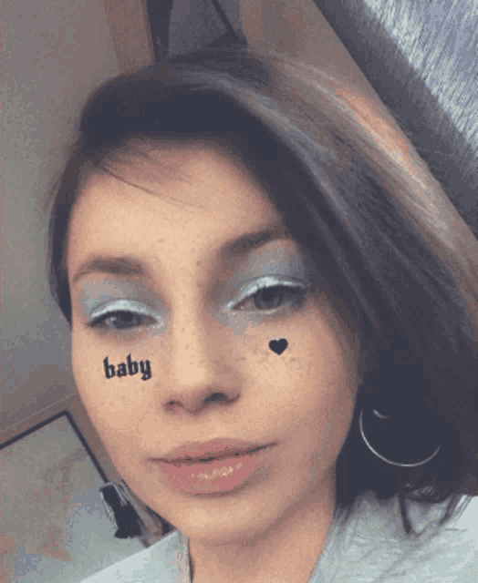 a woman with a baby tattoo on her face