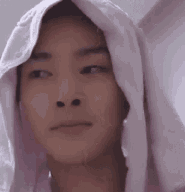 a young man with a towel wrapped around his head .