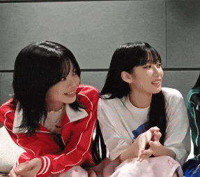 two girls are sitting next to each other and smiling for the camera