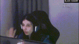 a woman wearing headphones is sitting at a desk in front of a computer screen .