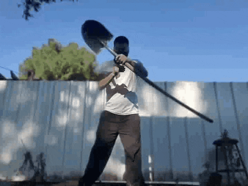a man wearing a mask is holding a shovel and a sword .