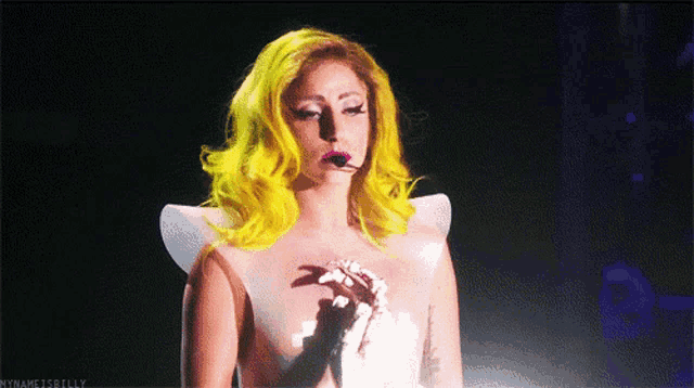 a woman with bright yellow hair is singing into a microphone with the hashtag mynameisbilly below her
