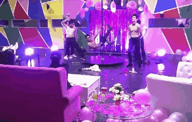 a group of men are dancing on a pole in a room