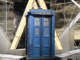 a blue police box is sitting in front of a triangle