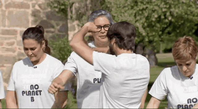 a group of people wearing t-shirts that say no planet b