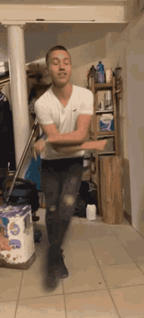 a man in a white shirt and black jeans is dancing