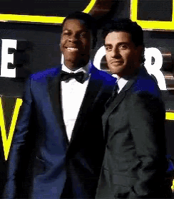 two men in suits and bow ties are standing next to each other and smiling .