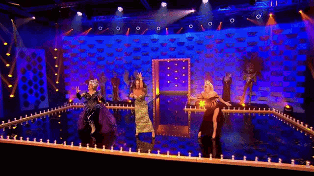 a group of women are dancing on a stage in front of a mirror .