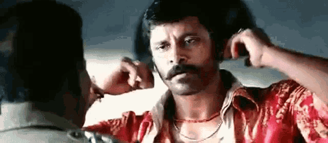 a man with a mustache is getting a punch in the face .