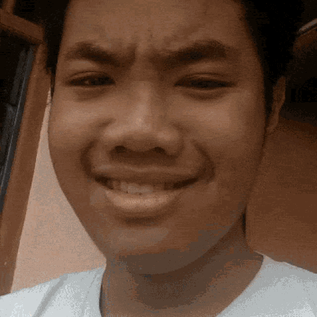 a close up of a young man 's face with a smile on his face
