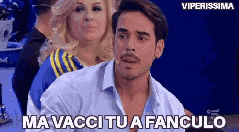 a man sitting in front of a woman with the words ma vacci tu a fanculo written on the screen