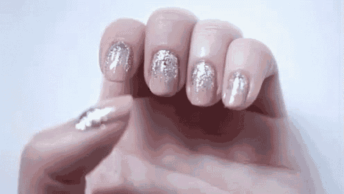 a close up of a woman 's nails with a silver glitter design .