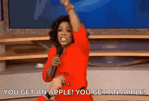 a woman in a red dress is holding a microphone and saying you get an apple !