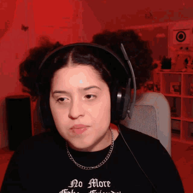 a woman wearing headphones and a shirt that says " no more "